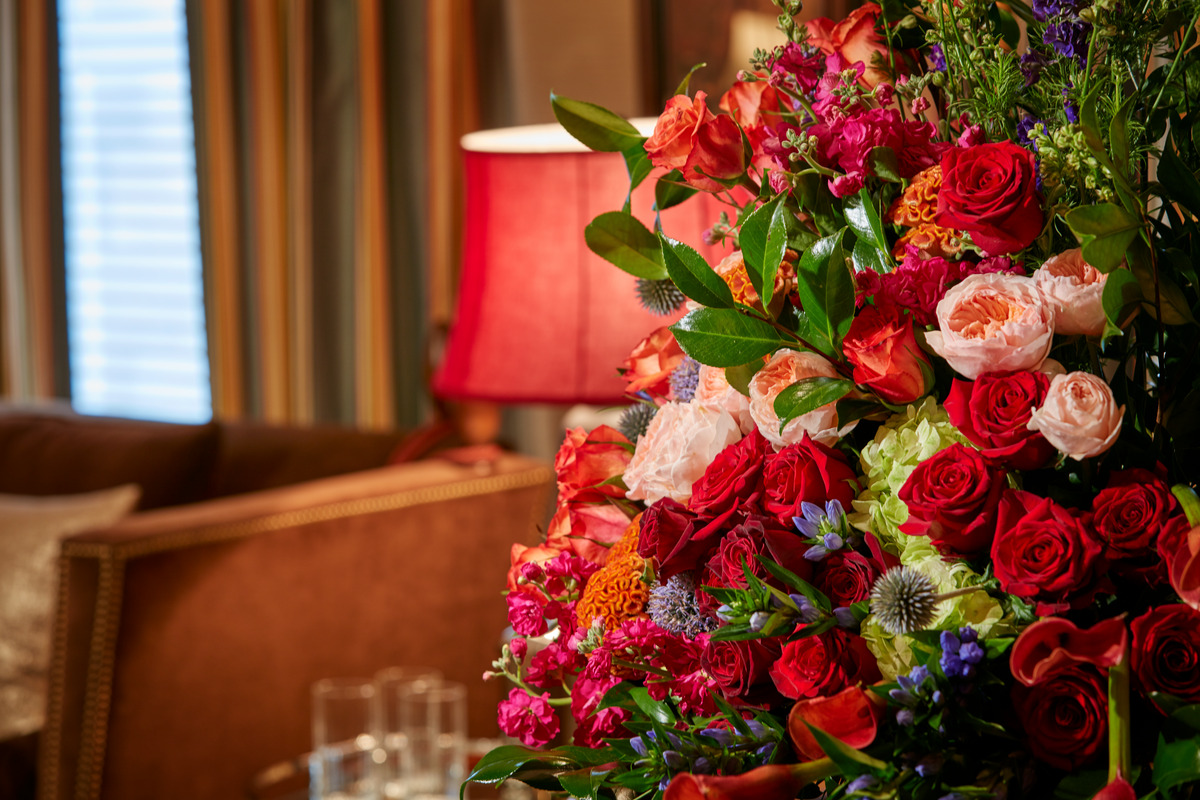 Floral arrangement in a vase on top of a table inside a funeral home. 