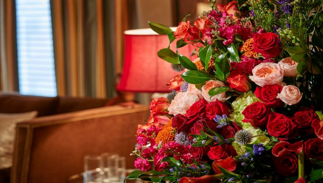 Floral arrangement in a vase on top of a table inside a funeral home. 