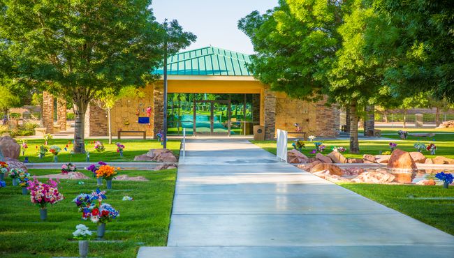 A pathway through a cemetery leads to a community mausoleum. 
