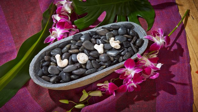 Tranquil black rocks in a bowl with love spelled out on top in white rocks. 