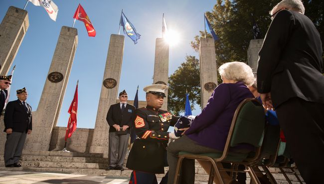 Military Funeral Honors are performed in front of the Armed Forces flags.