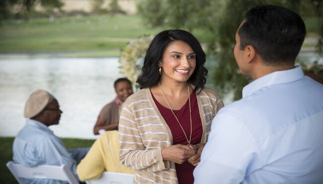 A woman talking to a man while standing at an outdoor service.
