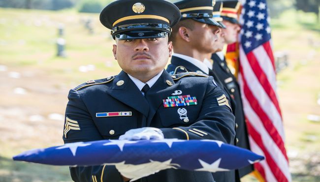 Soldier holding folded American flag