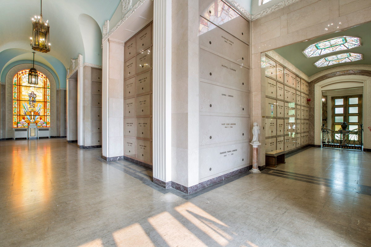 An indoor community mausoleum with a stained glass window, and polished marble details at Ocean View Funeral Home