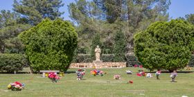 Cemetery grounds with a statue of Jesus holding the bible at Resthaven Park Cemetery.