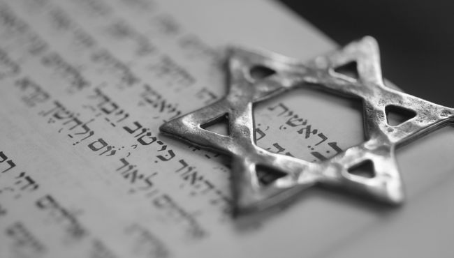 A silver Star of David sits over Hebrew writing.