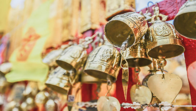 Golden prayer bells hang in a row.

