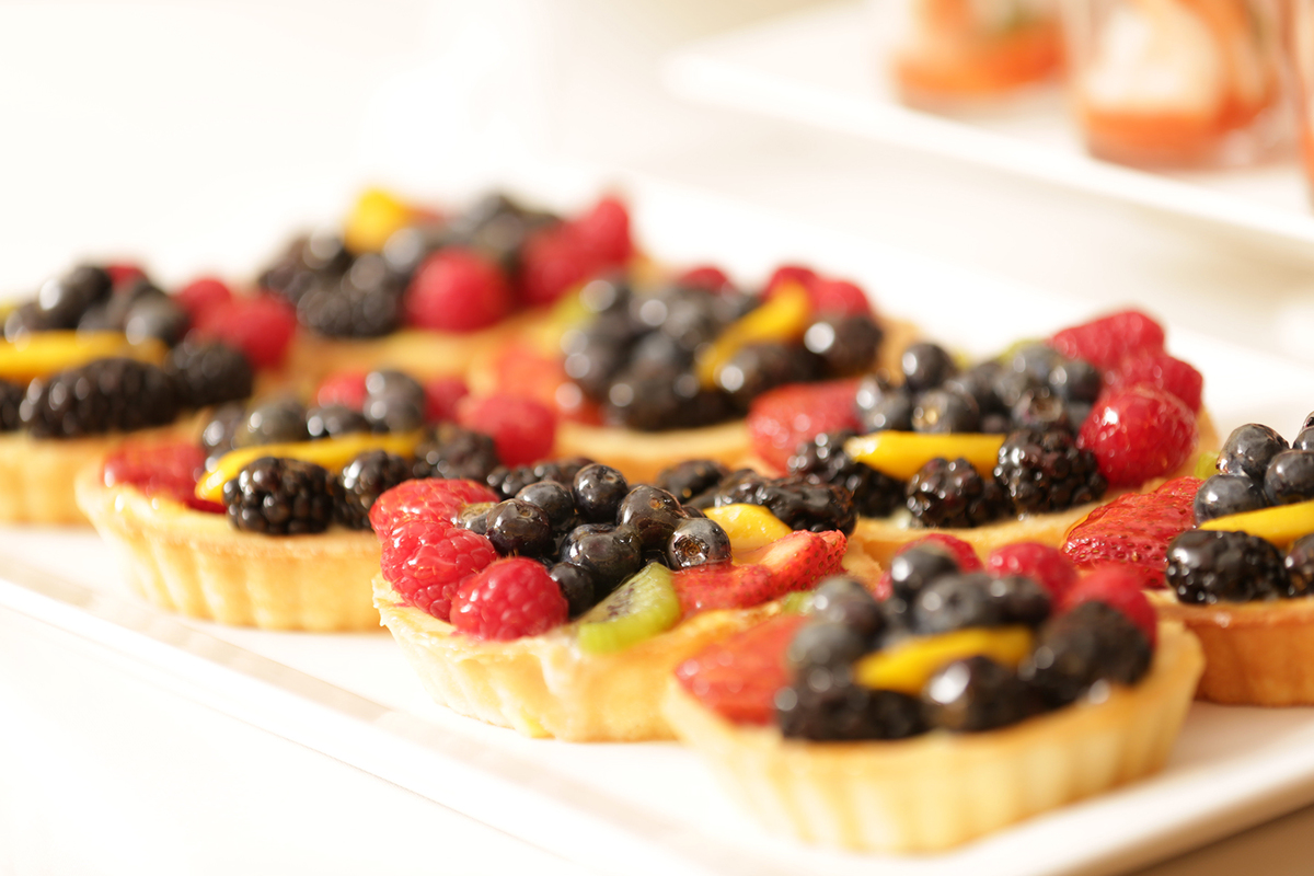 A tray of small fruit tarts for a catered reception.   need translation