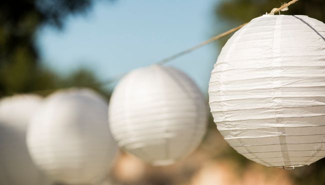 White paper lanterns hang from the trees.