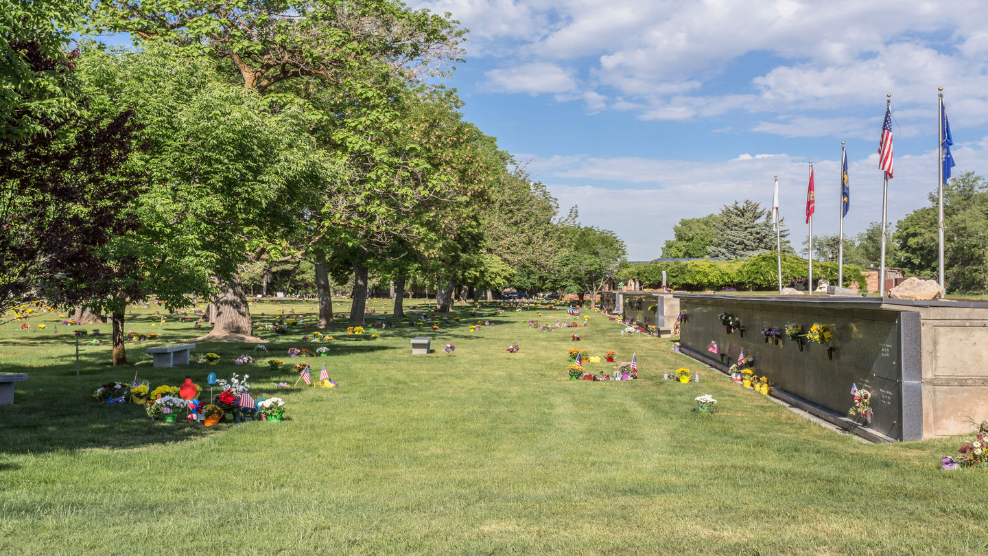 Cemetery grounds with flags and mausoleums at Wasatch Lawn Memorial Park.