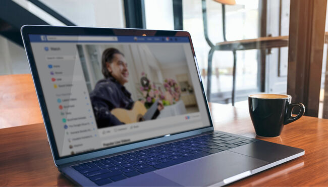 Laptop on wood tabletop with cup of hot coffee
