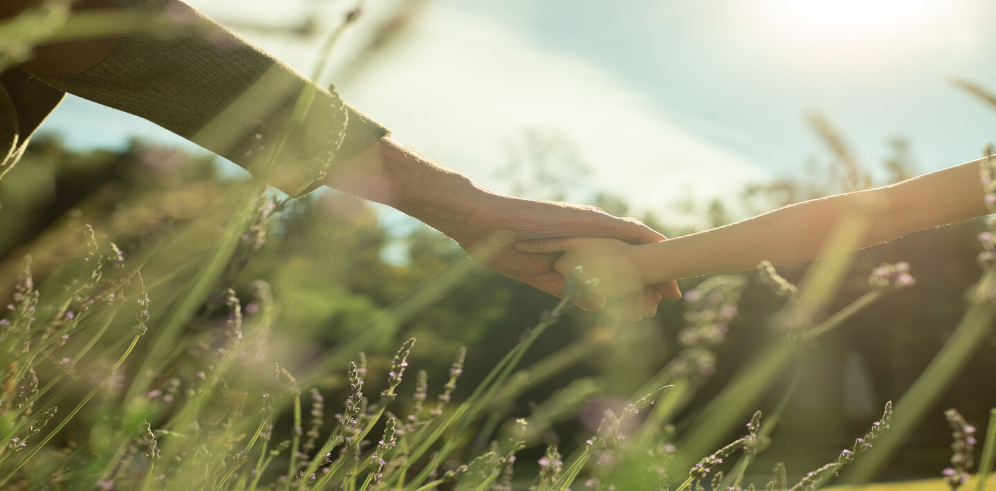 close up of grandfather and granddaughter holding hands