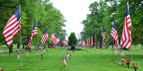 Row of American flags leading to a water fountain at Resthaven Cemetery